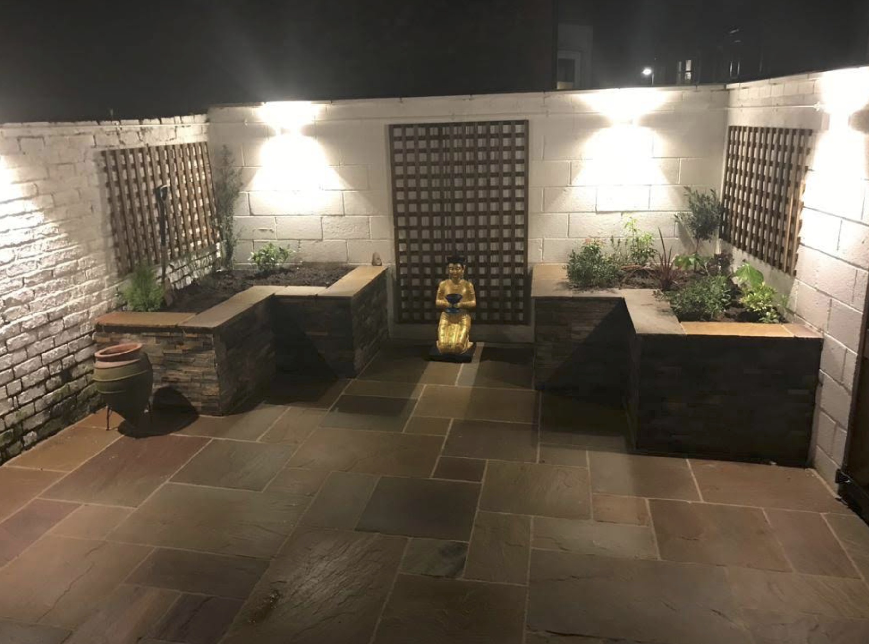 Landscaped courtyard with paving, raised beds, trellis and exterior lighting
