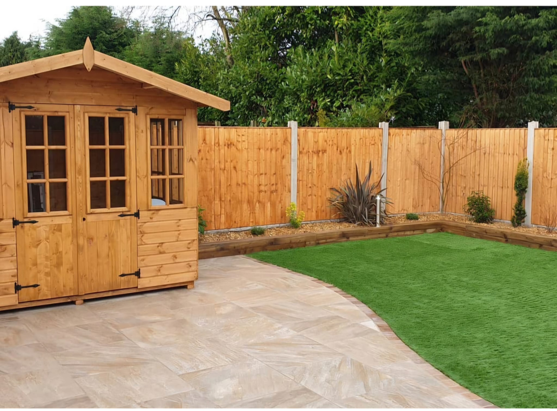 New timber boundary fencing beside a paved patio and landscaped garden